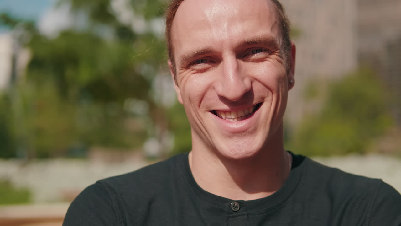Close up portrait of handsome European young man smiling, male student outdoors