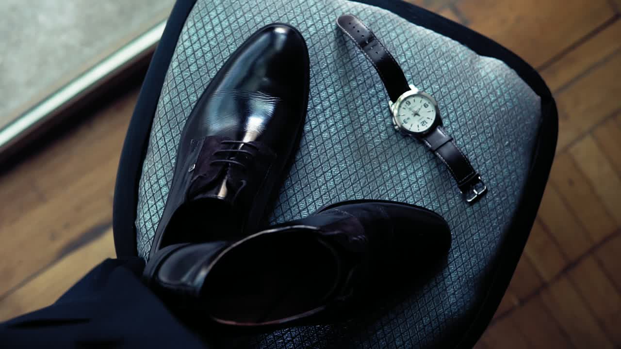 Man's accessories: shoes and watch. Accessories for a groom before ceremony. Slowmotion shot