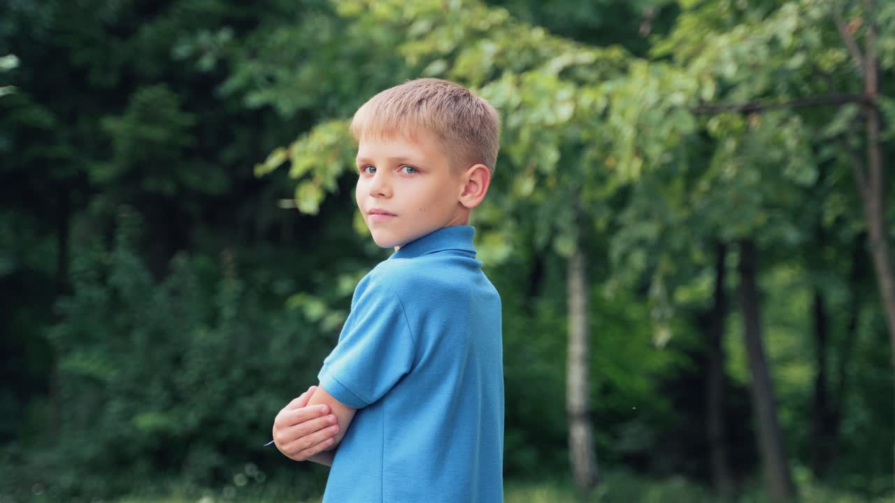 Child turns from his back and looks at the camera smiling. Portrait of a boy in a blue shirt