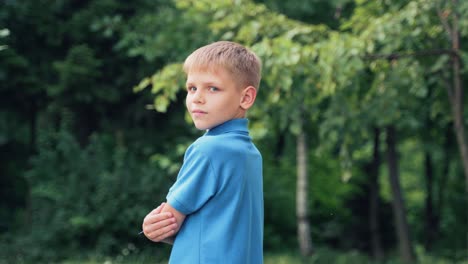 child turns from his back and looks at the camera smiling. portrait of a boy in a blue shirt
