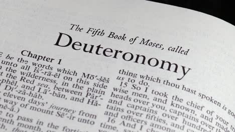 close up shot of bible turning to the book of deuteronomy