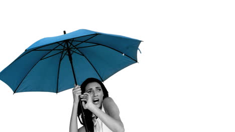 woman under blue umbrella cowering with fear