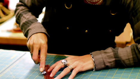 craftswoman cutting leather belt