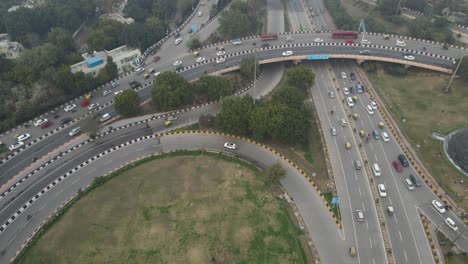 aerial drone shot displaying the continuous movement of vehicles on a delhi flyover, with buses and cars navigating through traffic.