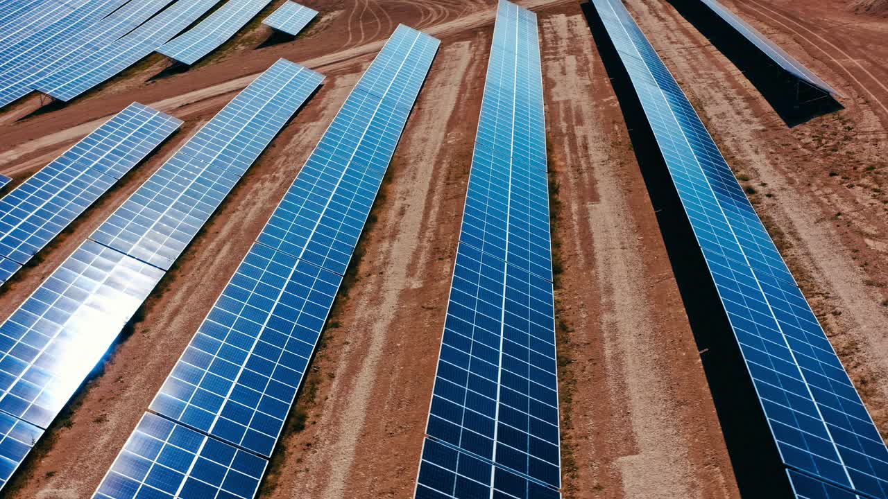 una vista aérea de paneles solares bien alineados en filas a través de un vasto paisaje