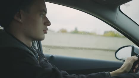 Side-View-Of-A-Handsome-Young-Man-Looking-Straight-On-The-Road-While-Driving-A-Car---Closeup-Shot,-Handheld