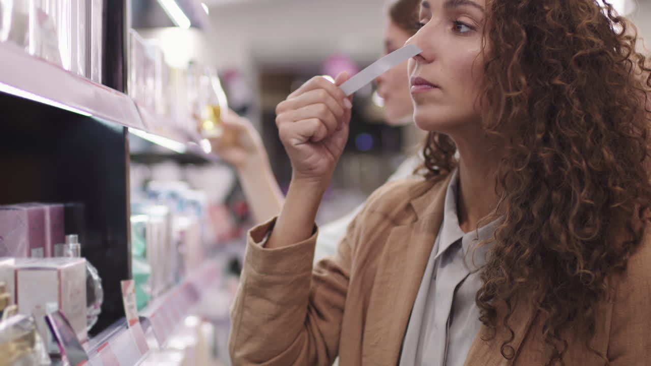 Pretty Woman Choosing Perfume In Beauty Shop