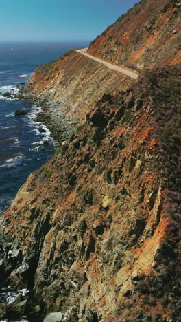craggy rugged coastline of california. dark blue pacific ocean with algae accumulation on surface. top view. vertical video