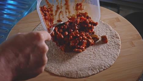 Filling-The-Tortilla-With-Cooked-Spicy-Chicken-Bean---close-up