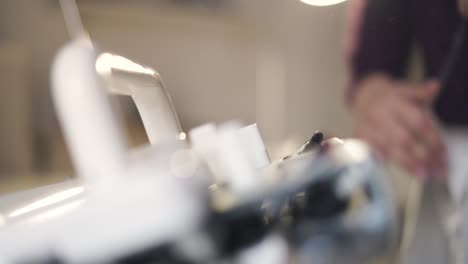 Female-hands-working-on-weaving-machine-for-making-knitted-texture