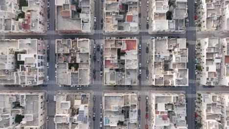 Imágenes-Aéreas-En-Lento-Descenso-De-Los-Barrios-Cuadrados-De-Monopoli,-Italia