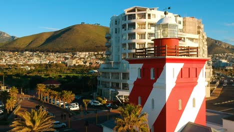 a drone ascending and revealing the green point lighthouse in cape town, south africa