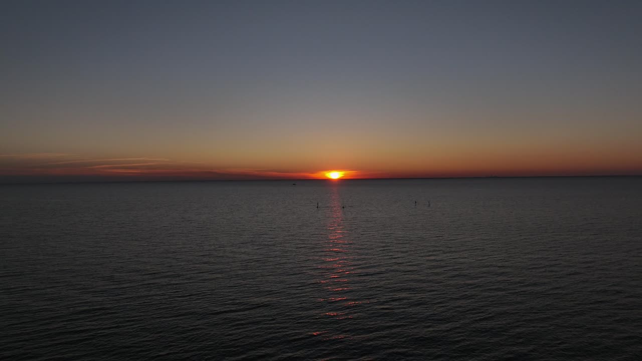 Luftfoto i revers af solnedgang, mens en motorbåd sejler forbi