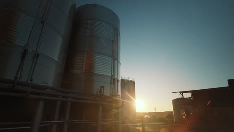 Reihe-Von-Weinsilos-Aus-Stahl-Bei-Sonnenuntergang