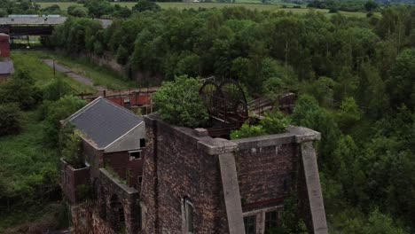 abandoned old overgrown coal mine industrial rusting pit wheel aerial view rising over