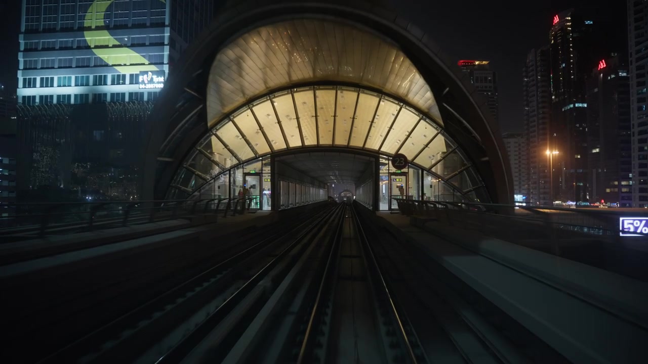 Vista da un treno della metropolitana in movimento che entra in una stazione di notte