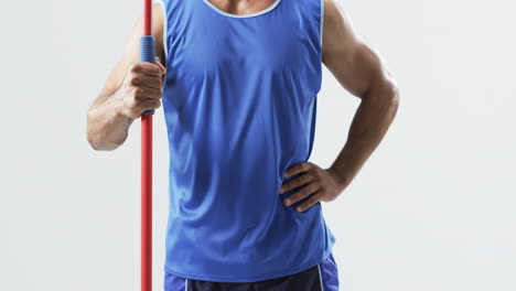 young biracial athlete man holding a javelin on a white background