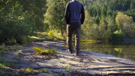 a guy walks along the shoreline