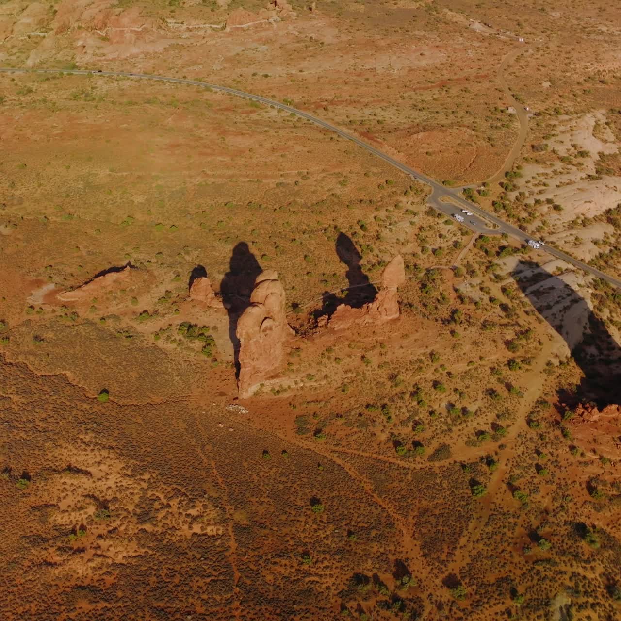Few lonely little rocks among the deserted landscape. Highway crossing the scenery with some cars going by. Top view