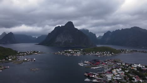 steep norwegian cliffy reinebringen mountains and reine fishing villages on islands surrounded by fjords and sea in nordland county of norway - establishing aerial