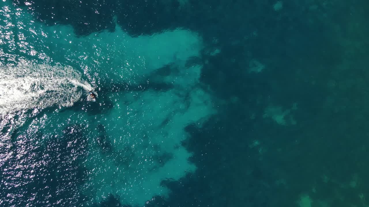 Veduta aerea dall'alto di due moto d'acqua che si godono le acque cristalline di Sa Fig, sull'isola di Ibiza in Spagna.