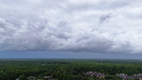 timelapse of large, rolling clouds forming above a dense green forest in vilano beach, st