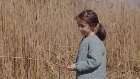 young girl playing in a reed field