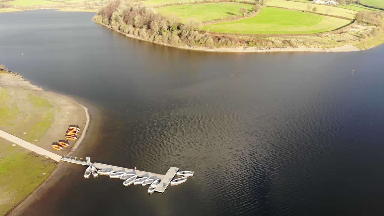부두 옆에 빈 보트가 있는 서머셋의 엑스무어에 있는 윔블볼 호수 위의 공중