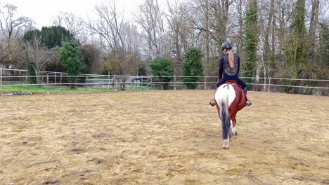 female jockey riding her pony in the paddock