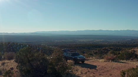 antena baja que pasa por tierra 4x4 suv en un camping panorámico en el desierto, 4k