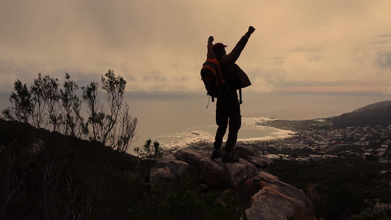 Coastal city view from mountain under cloudy sky