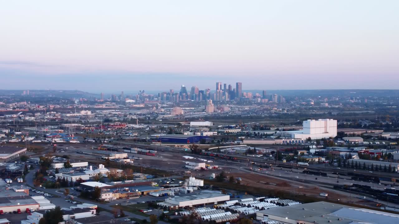 칼가리 시내의 아침 일출 사진. 전면에 열차와 증기 지붕이 있습니다.