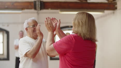 Plano-Medio-De-Una-Pareja-De-Ancianos-Bailando-Vals-En-El-Salón-De-Baile-Y-Aplaudiendo-Con-Todo-El-Grupo