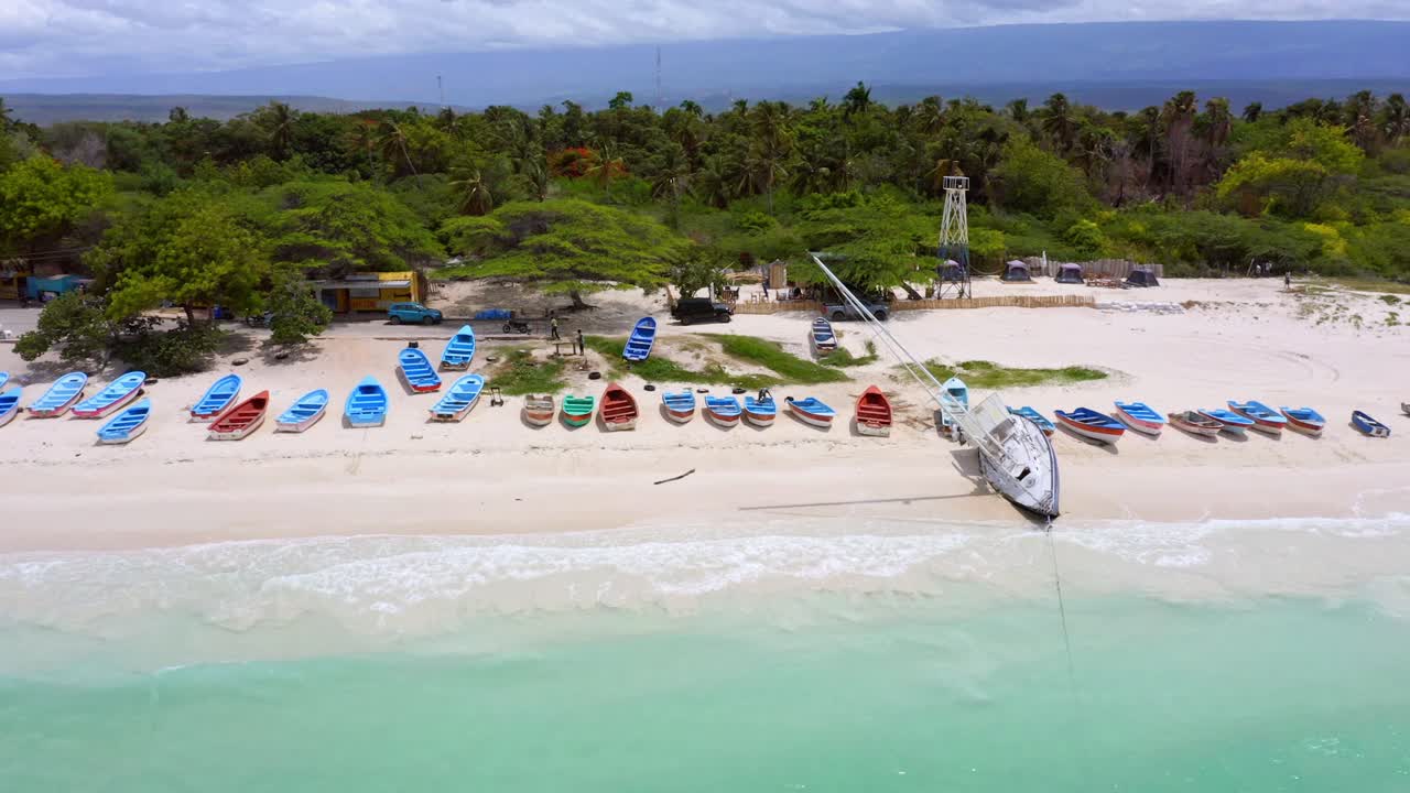 iluminación solar en aguas claras del océano, playa dorada, botes coloridos y paisajes verdes en el fondo de una isla tropical