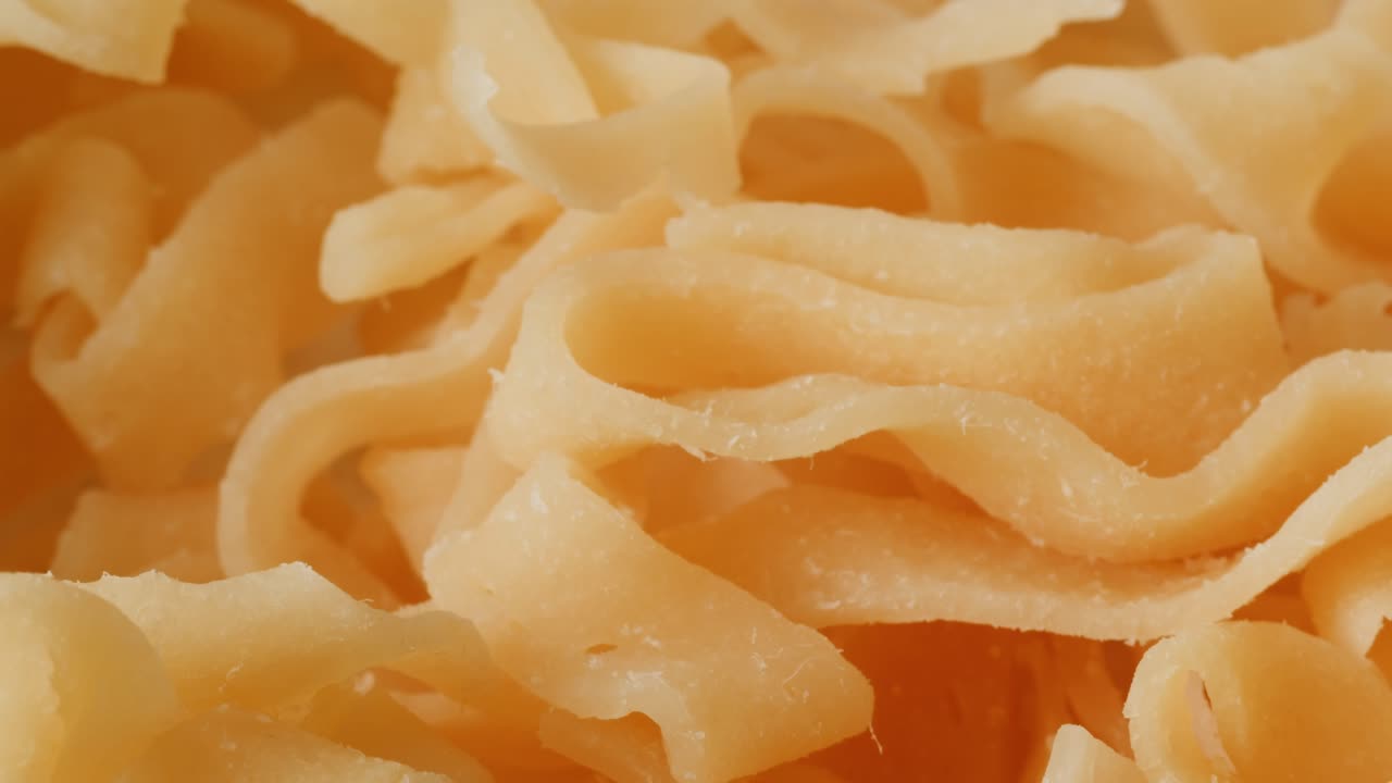 Close-up view of dried, light orange noodles