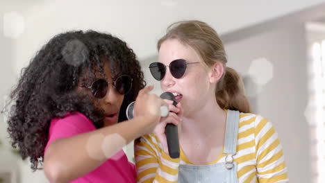 Animación-De-Luces-Sobre-Adolescentes-Felices-Y-Diversas-Con-Gafas-De-Sol-Y-Micrófonos-Cantando-En-Casa