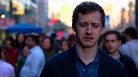 hombre triste llorando en una multitud de la ciudad