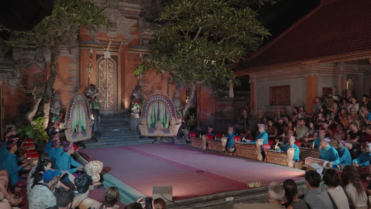 Tourists Enjoy Listening Musicians Play on Gangsa Metallophones and Kendang Drums During Legong Theatrical Dance Performance at Ubud Palace, Bali - wide angle
