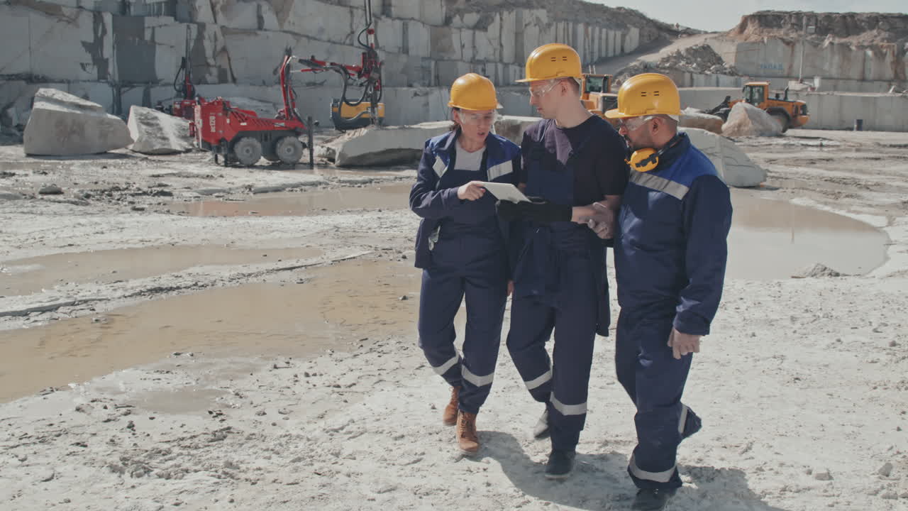 Workers with Tablet Inspecting Granite Quarry