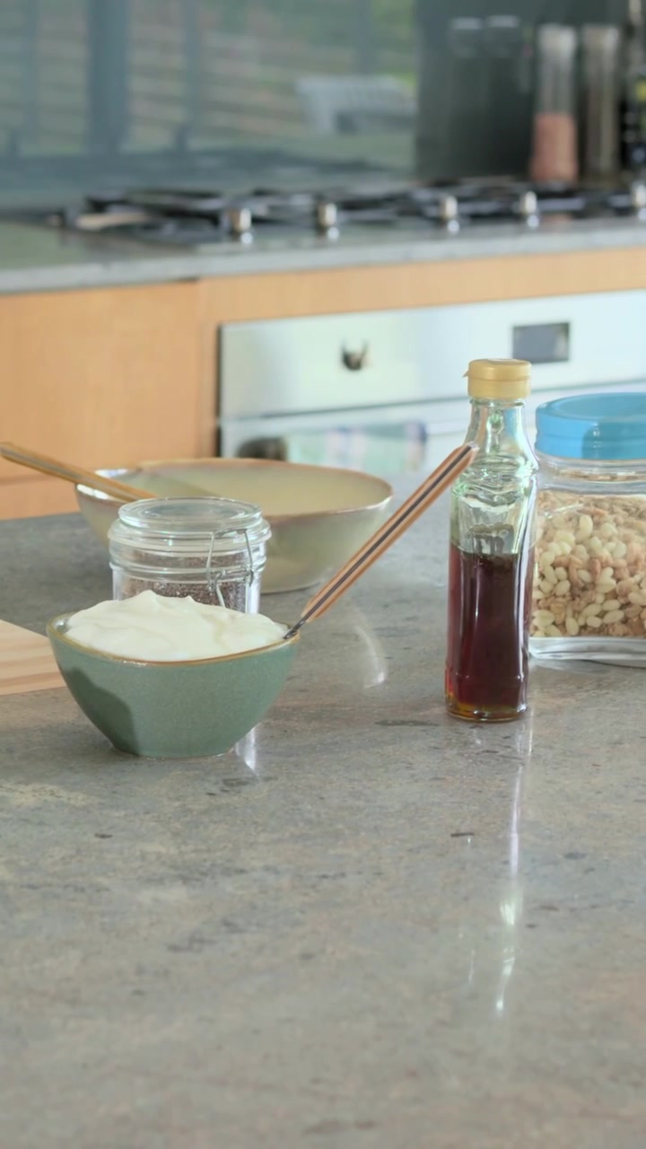 Vertical video: Panning camera across kitchen counter, centering jar with blue lid, copy space