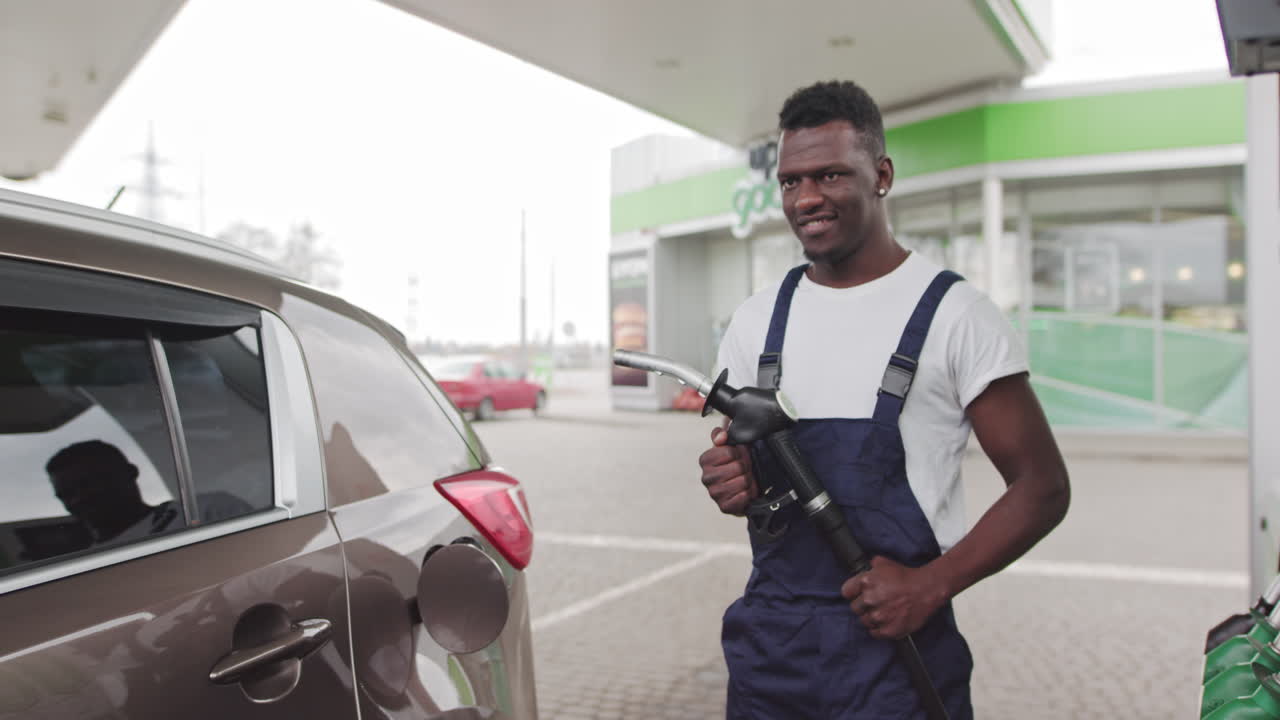 Man fueling a car at a gas station