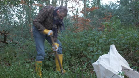 Ein-Reifer-Mann,-Der-Im-Wald-Gräbt,-Um-Bäume-Zu-Pflanzen,-Die-Die-Umgebung-Bewundern