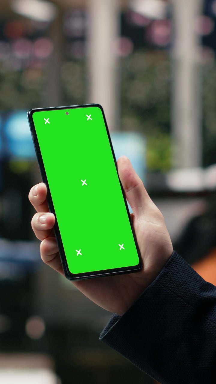 Video verticale. Smartphone con schermo isolato utilizzato da un uomo d'affari in un nodo di trasporto.