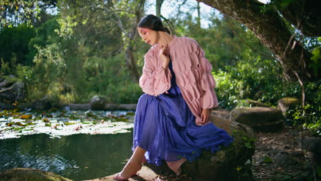 charming woman relaxing near lake beautiful forest. girl nymph sitting at pond