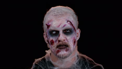 unerwartetes auftreten eines unheimlichen mannes mit schrecklichem halloween-zombie-make-up, der versucht zu erschrecken