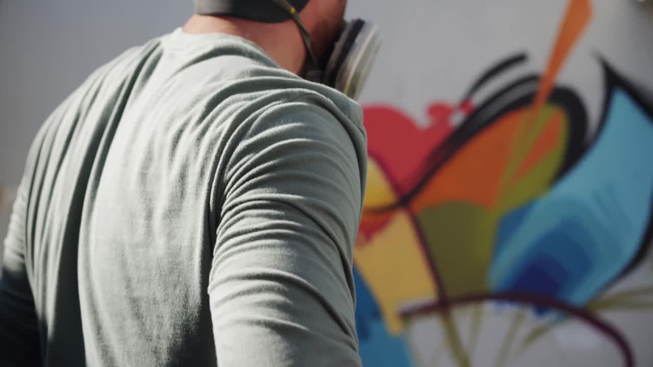 Graffitaro che guarda il muro sotto il sole 4k