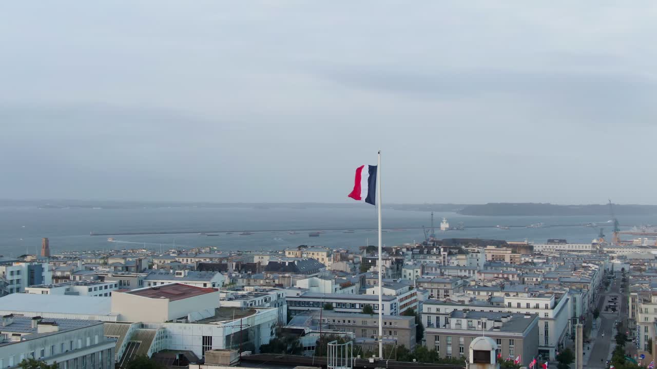 Majestic soft aerial orbit round french flag with city skyline of Brest, France in background