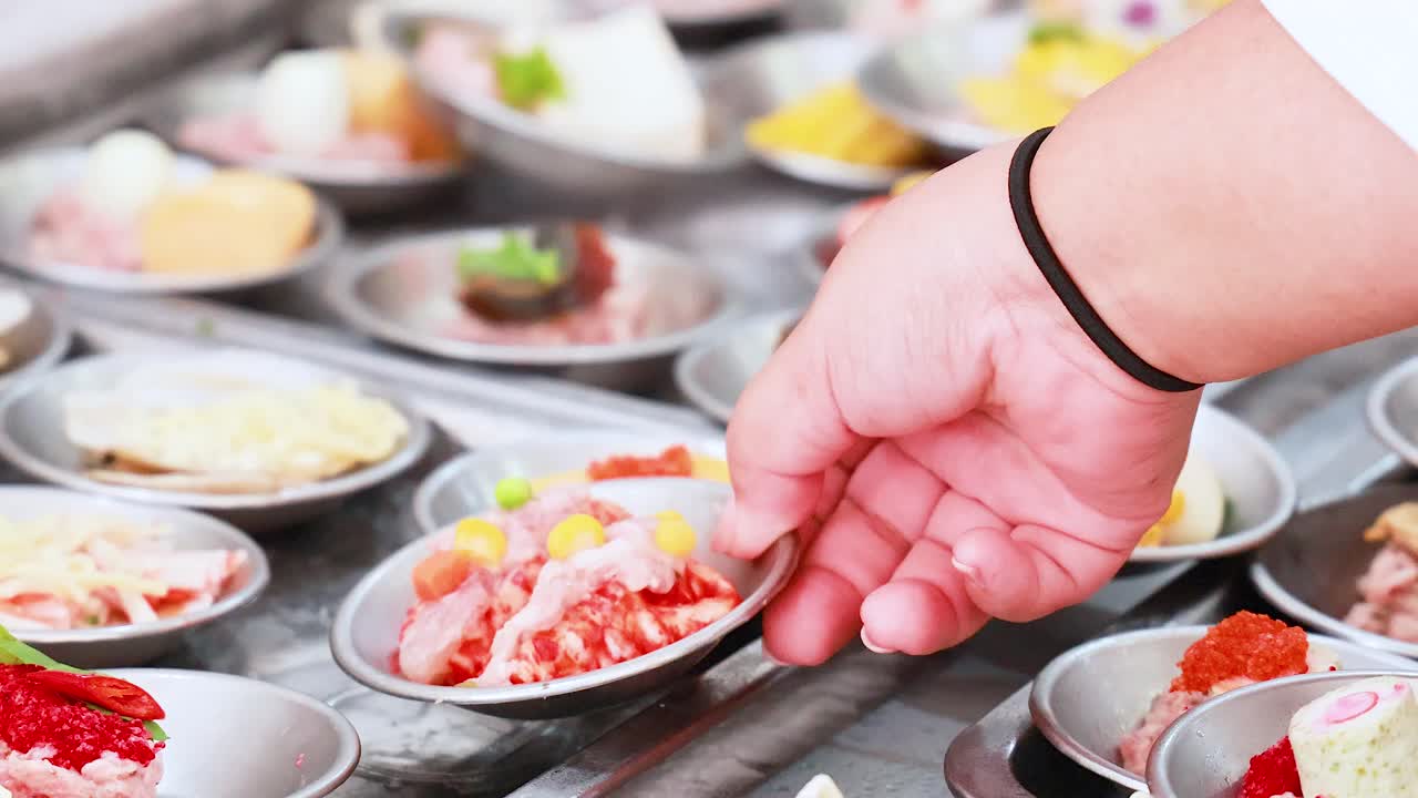 한 손이 활기찬 푸켓 시장에서 다양한 요리 중에서 섬을 선택하여 지역 요리를 선보입니다.