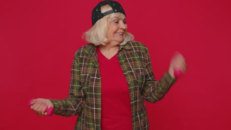 anciana anciana haciendo ejercicios de fitness con pesas, trabajando bombeando los músculos del brazo