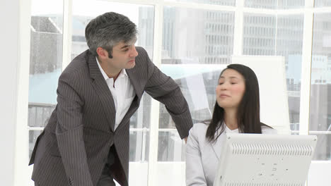 mature manager helping a woman with the computer